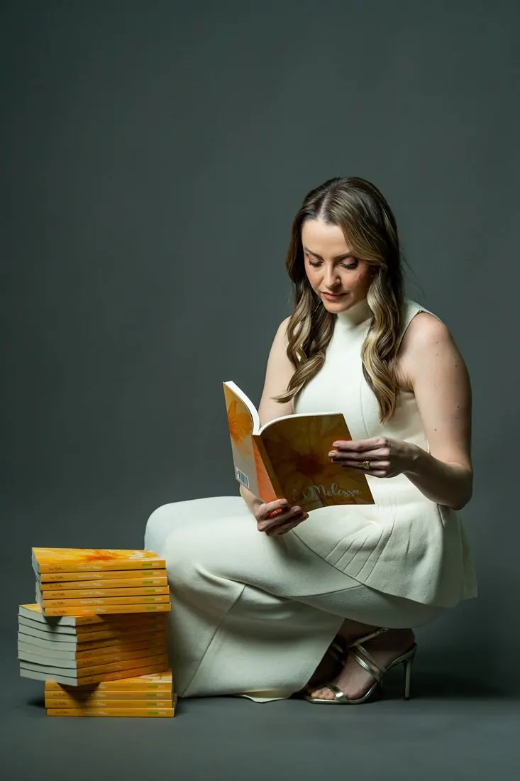 Ana com uma pilha de exemplares do livro